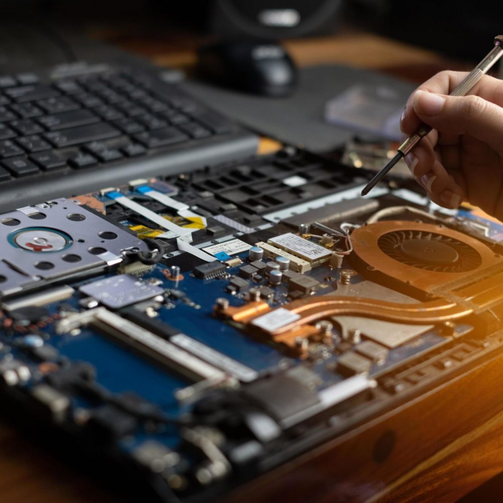 technician-repairing-broken-laptop-notebook-computer-with-a-screwdriver-free-photo